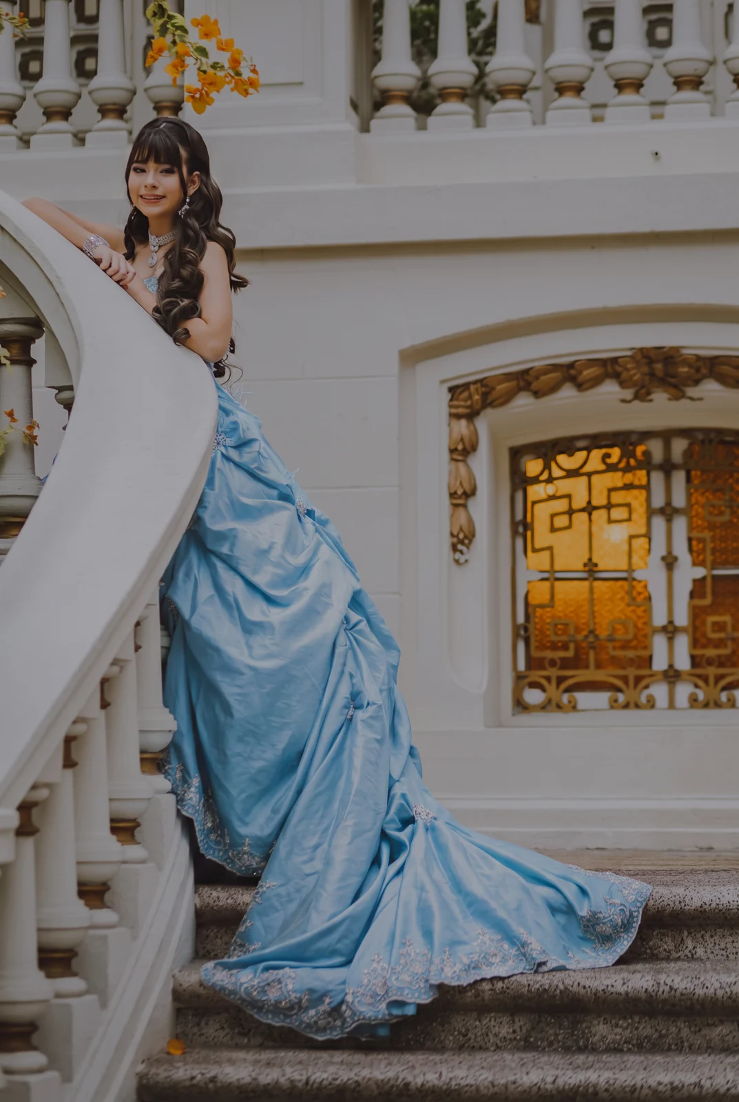 Lusangella con vestido azul en las escaleras del palacio